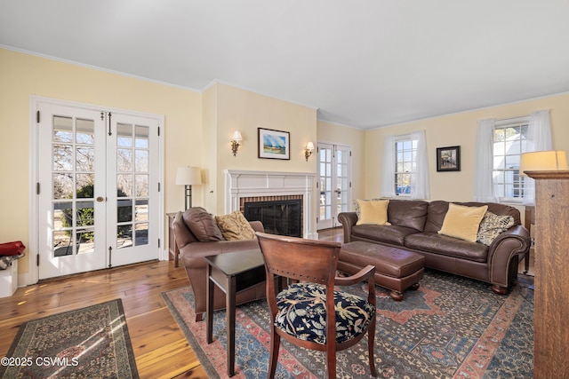 living room with a fireplace, french doors, and hardwood / wood-style floors