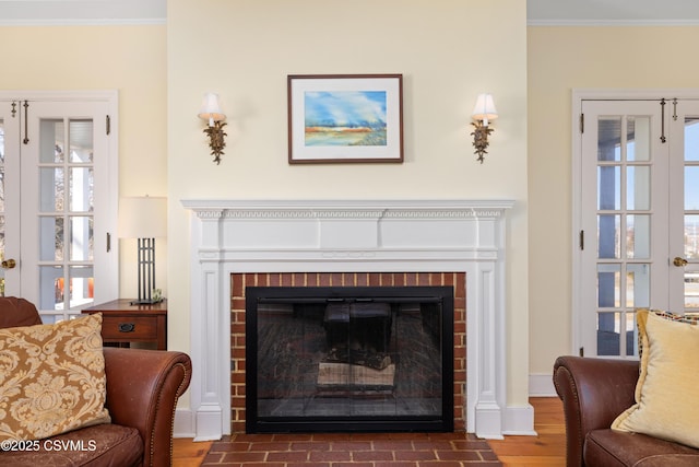 interior space with wood finished floors, ornamental molding, and a fireplace