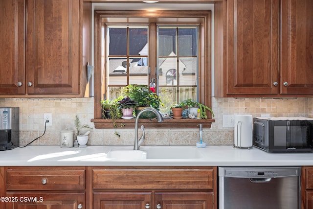 kitchen featuring a sink, light countertops, black microwave, dishwasher, and backsplash