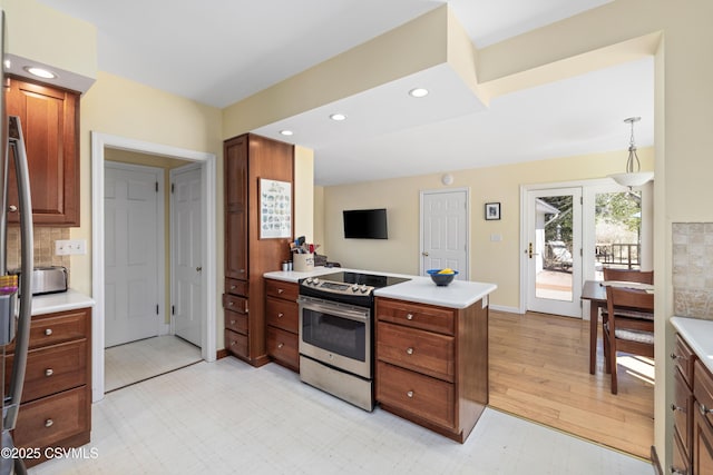 kitchen featuring tasteful backsplash, stainless steel electric range oven, light countertops, recessed lighting, and a peninsula