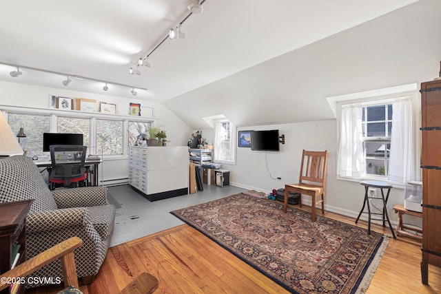 living room featuring a baseboard heating unit, lofted ceiling, wood finished floors, and baseboards