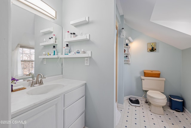 bathroom featuring baseboards, toilet, lofted ceiling, tile patterned floors, and vanity