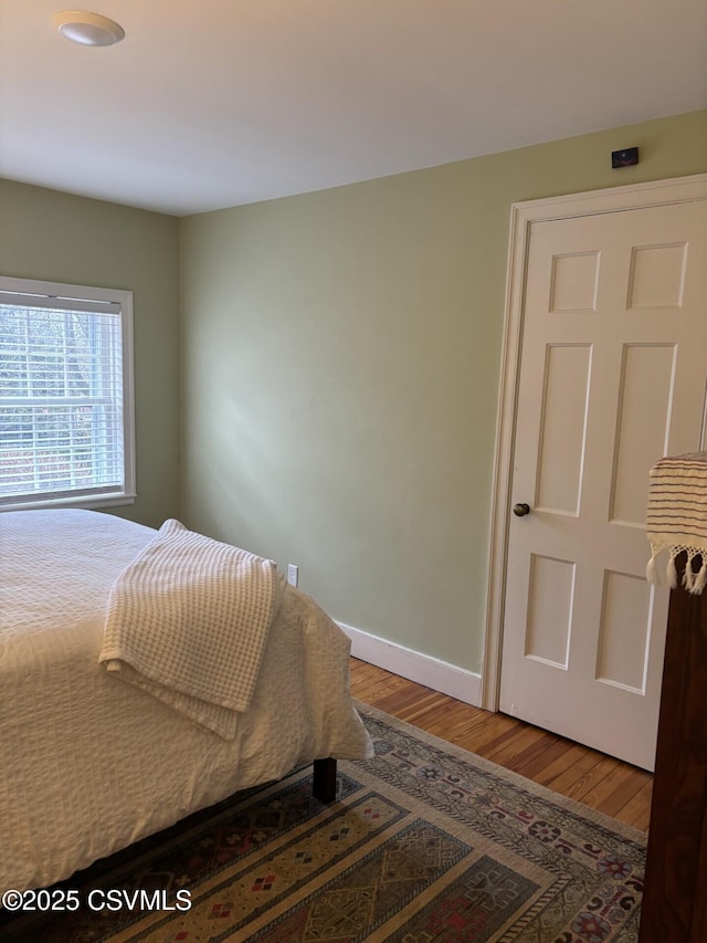 bedroom featuring wood finished floors and baseboards