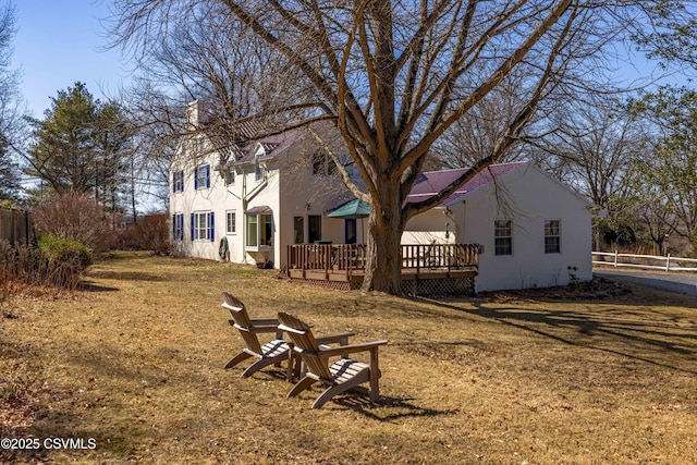 view of yard featuring a fire pit, fence, and a wooden deck