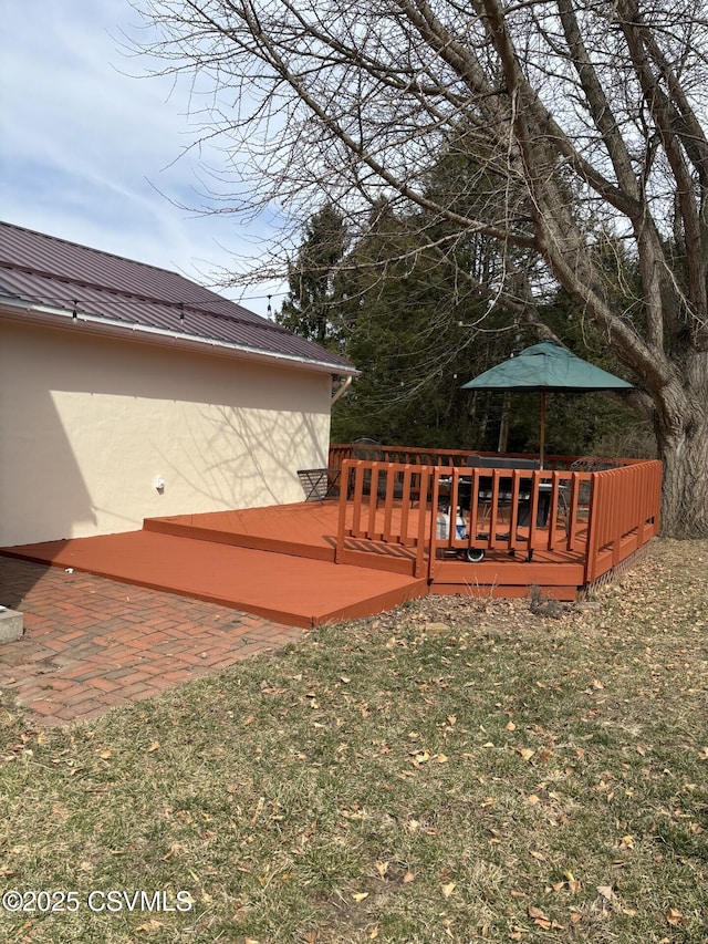 wooden deck featuring a lawn