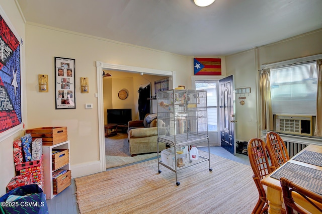 living area featuring cooling unit, baseboards, and wood finished floors