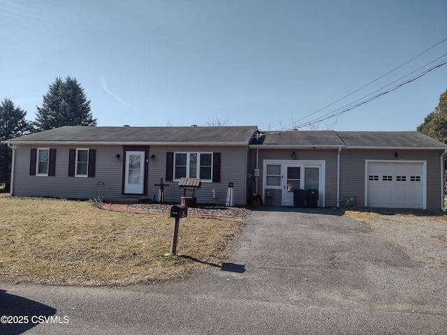 ranch-style house featuring aphalt driveway, an attached garage, and a front yard