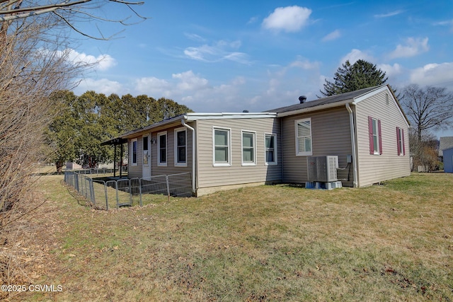 back of house with a yard, central air condition unit, and fence