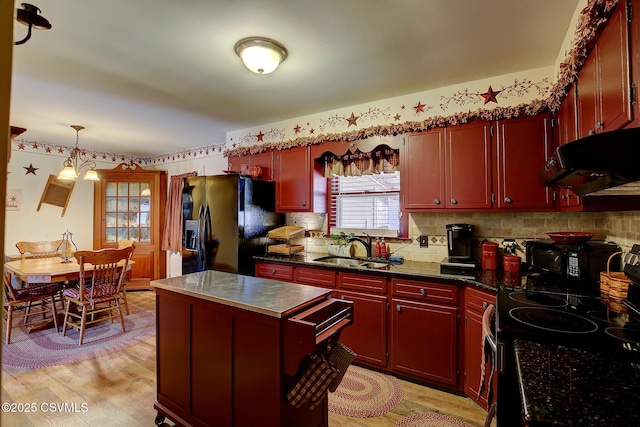 kitchen with light wood-style flooring, a sink, black appliances, dark brown cabinets, and under cabinet range hood