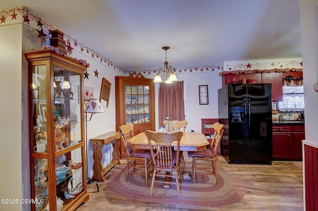 dining room featuring a notable chandelier and light wood-style floors