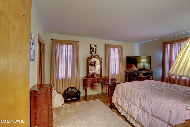 bedroom with multiple windows and wood finished floors