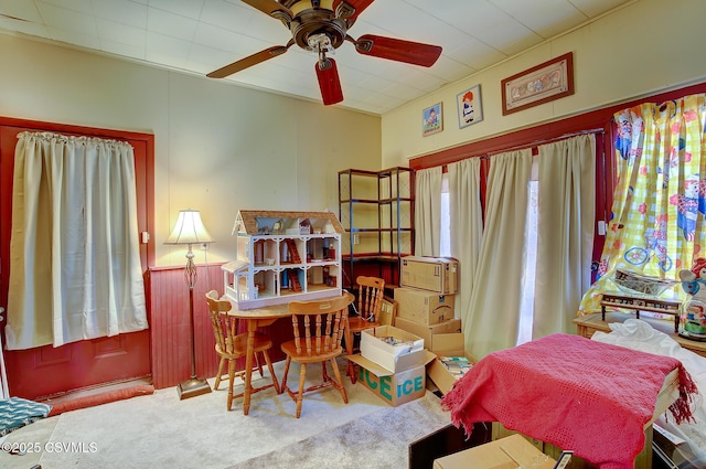 bedroom featuring ceiling fan, carpet flooring, and wainscoting