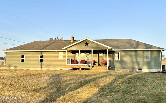 back of property featuring a chimney, a porch, a shingled roof, and a yard