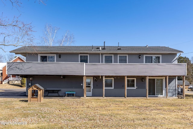 back of house with a lawn and a balcony