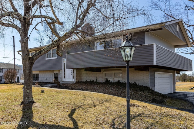 view of front of property with an attached garage, driveway, and a front lawn