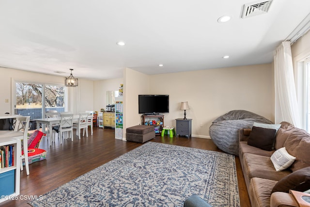 living room with an inviting chandelier, dark wood-type flooring, recessed lighting, and visible vents