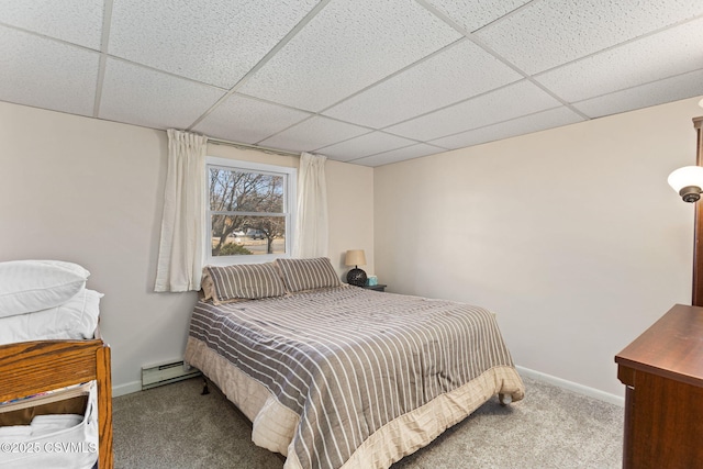 bedroom featuring a paneled ceiling, a baseboard heating unit, carpet floors, and baseboards