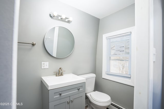 bathroom with vanity, toilet, and a baseboard heating unit