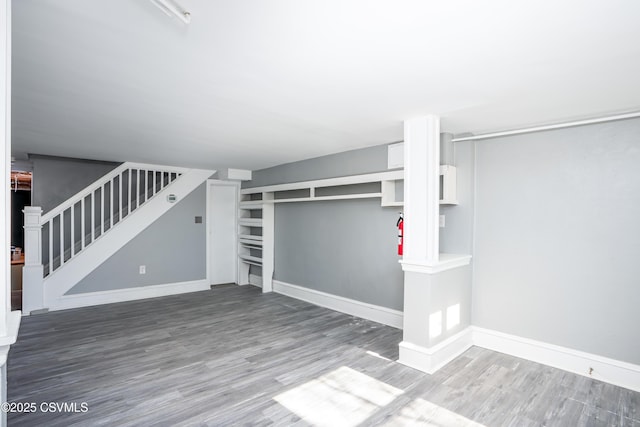 below grade area with stairway, baseboards, and wood finished floors