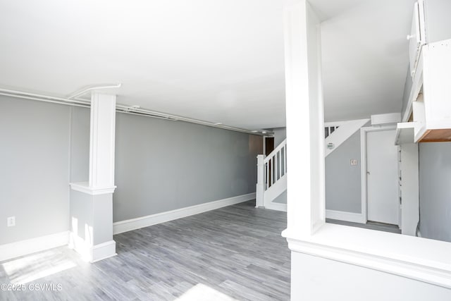 finished basement with stairs, baseboards, and wood finished floors