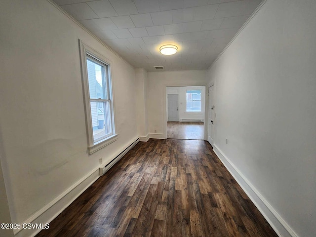 interior space with a baseboard radiator, baseboards, dark wood-style floors, and ornamental molding