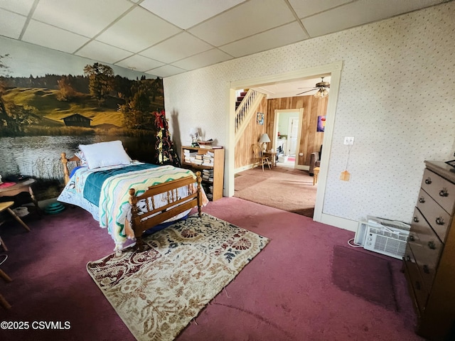 carpeted bedroom with wallpapered walls, baseboards, and a drop ceiling