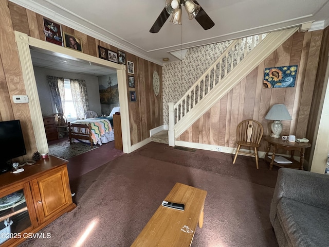 living room featuring stairway, baseboards, ornamental molding, and a ceiling fan