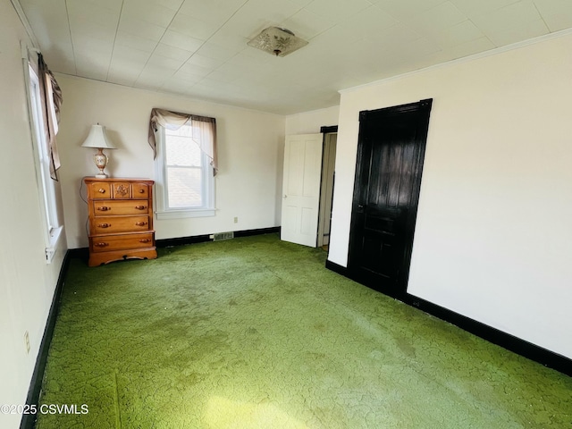 unfurnished bedroom with visible vents, baseboards, carpet, and crown molding