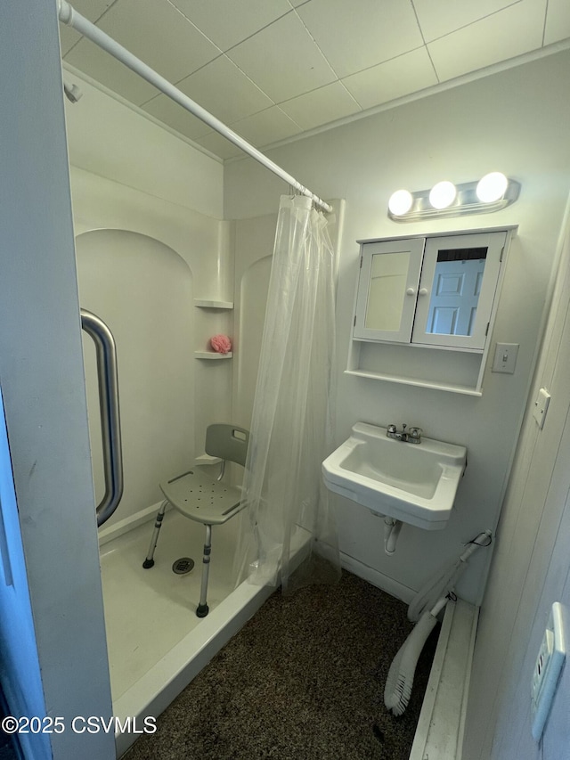 full bathroom featuring a shower with shower curtain and a sink