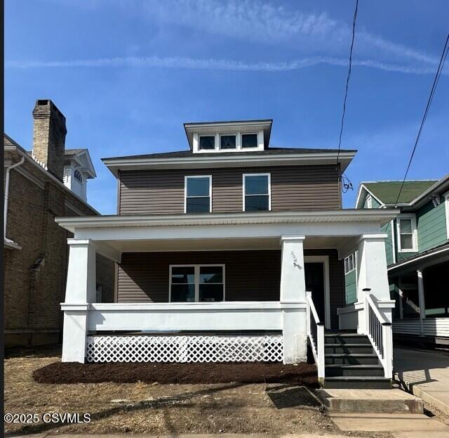 american foursquare style home with covered porch