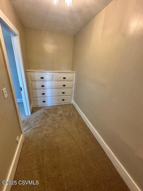 hallway featuring baseboards and carpet floors