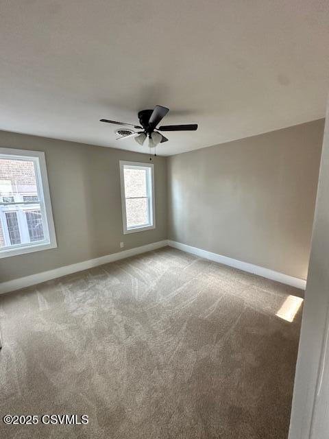 spare room with ceiling fan, baseboards, and carpet floors