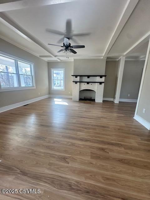 unfurnished living room featuring a fireplace, wood finished floors, baseboards, and ceiling fan