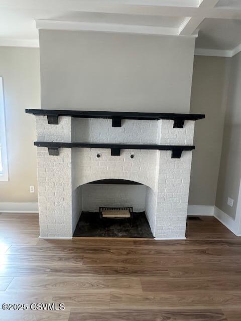 interior details featuring a brick fireplace, crown molding, baseboards, and wood finished floors