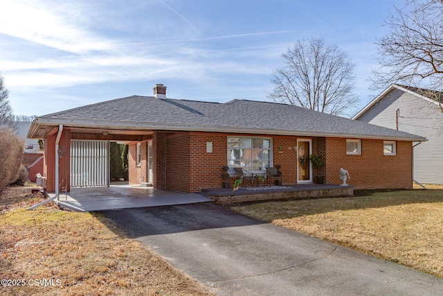 ranch-style house featuring a front lawn, brick siding, and a shingled roof