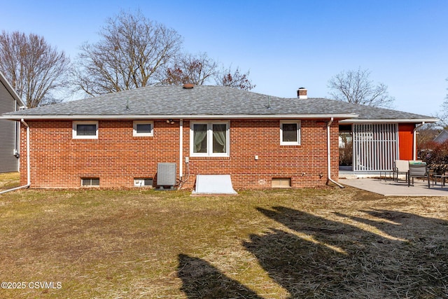 rear view of house featuring a shingled roof, a lawn, central air condition unit, a patio area, and brick siding