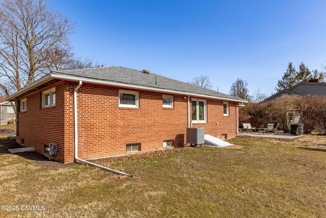 rear view of house featuring cooling unit, a patio area, brick siding, and a lawn