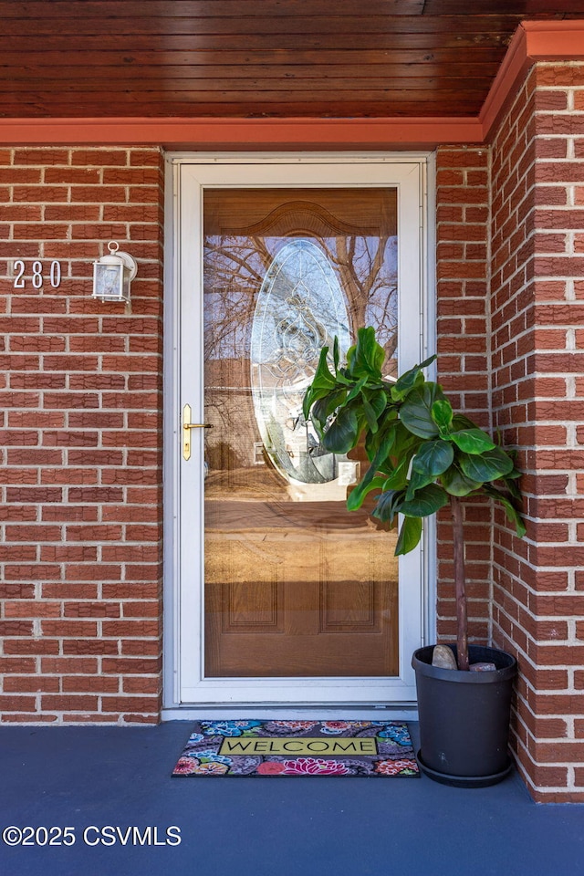 doorway to property with brick siding