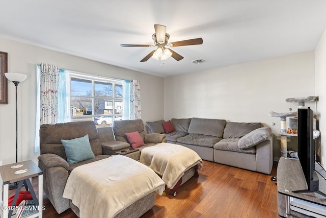 living area featuring a ceiling fan, wood finished floors, and visible vents