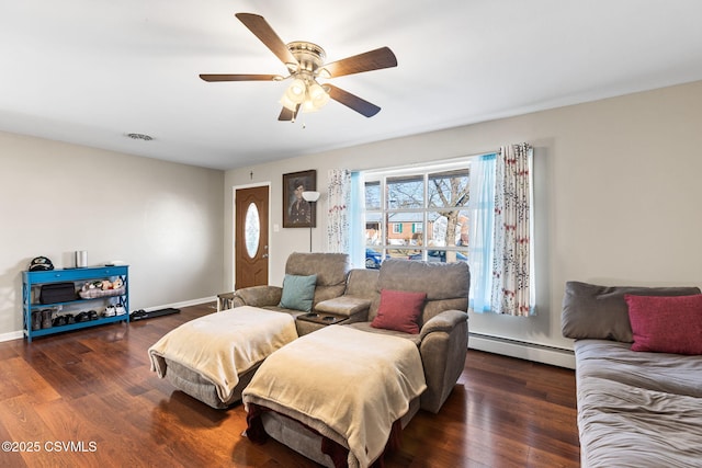 bedroom featuring a baseboard heating unit, wood finished floors, visible vents, and ceiling fan