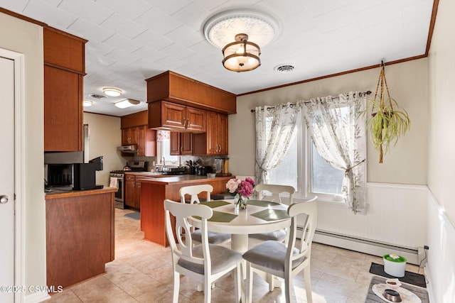 dining space featuring light tile patterned floors, a wainscoted wall, visible vents, a baseboard radiator, and ornamental molding