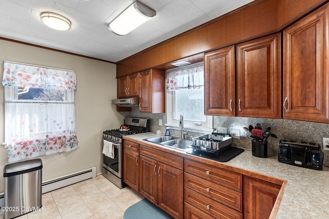 kitchen with stainless steel range with gas stovetop, a sink, light countertops, under cabinet range hood, and baseboard heating