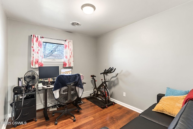 office space featuring visible vents, baseboards, and wood finished floors