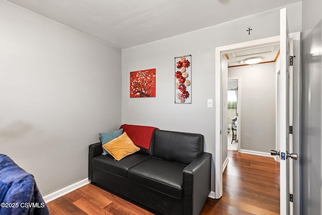 living room featuring baseboards, attic access, and wood finished floors