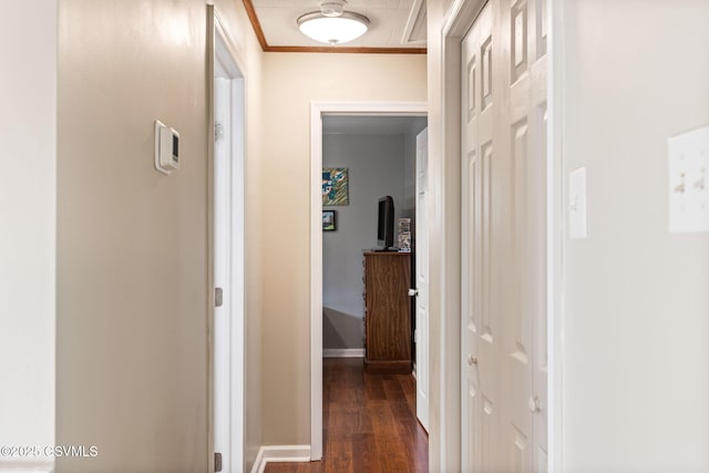 corridor featuring baseboards, dark wood-type flooring, and crown molding