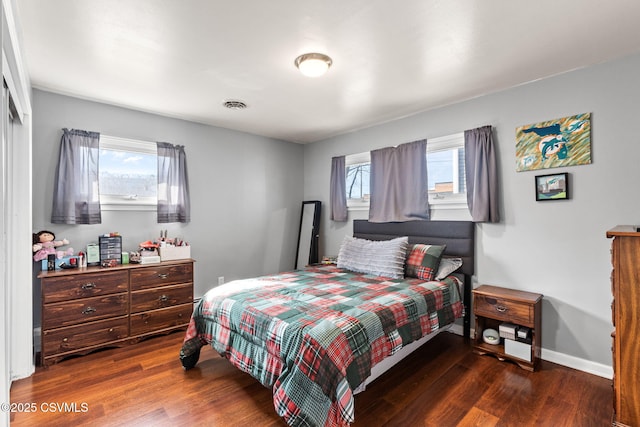 bedroom featuring dark wood-style floors, visible vents, and baseboards