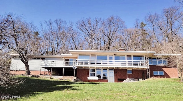 back of property featuring brick siding, a deck, a chimney, and a yard