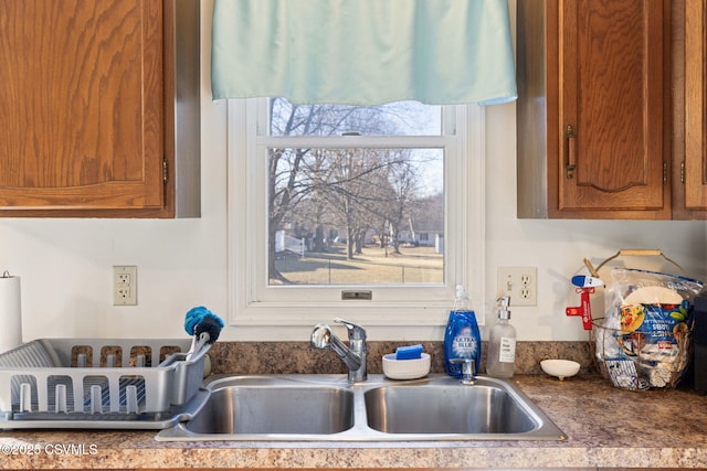 kitchen with dark countertops, brown cabinets, and a sink