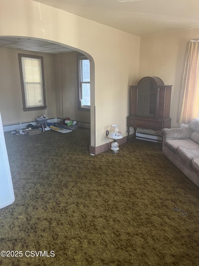 1035 W Walnut St, Coal Township, PA 17866 - unfurnished living room featuring arched walkways, carpet flooring, healthy amount of natural light, and baseboards