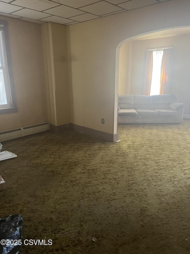 1035 W Walnut St, Coal Township, PA 17866 - empty room with a baseboard radiator, dark carpet, arched walkways, a drop ceiling, and baseboards